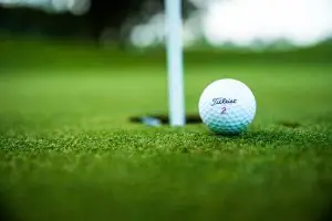 Golfer swinging on a fairway at sunset hero background